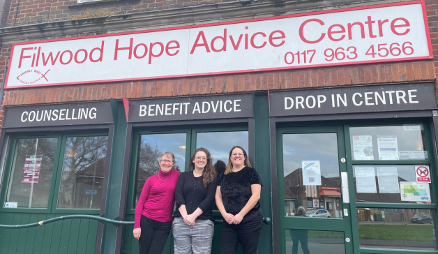 Three people stand outside the office of Filwood Hope Advice Centre in South Bristol who offer benefit advice, counselling and a drop-in service.